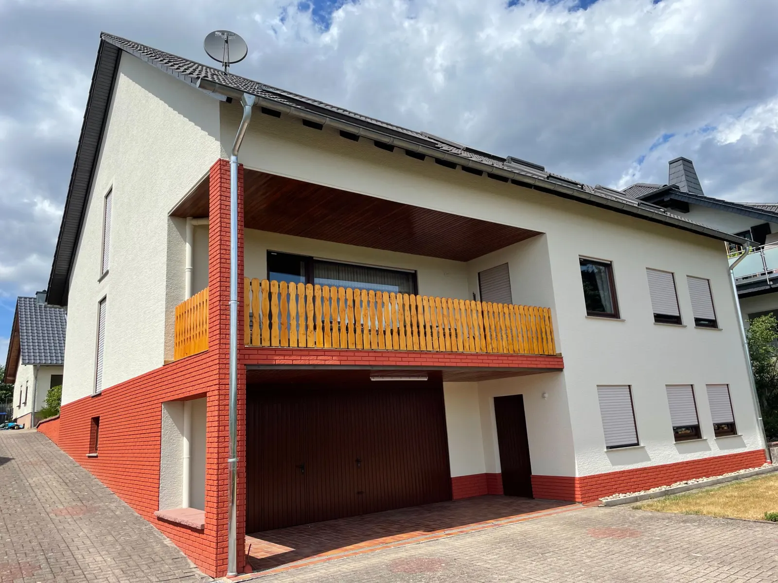 Fassade in Weiß mit rot abgesetztem Sockel